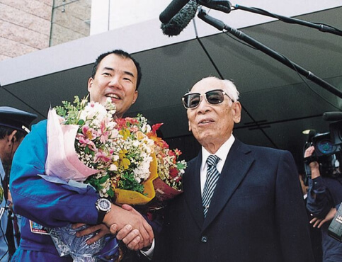 Ông Ando bắt tay phi hành gia Noguchi. Ông Ando bắt tay phi hành gia Noguchi.