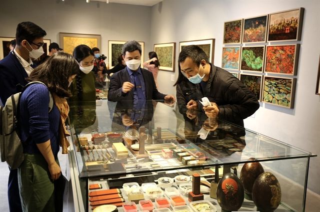 展覧会の来場者に漆の材料を紹介するアーティストのティエンさん　ⓒ VietnamNews